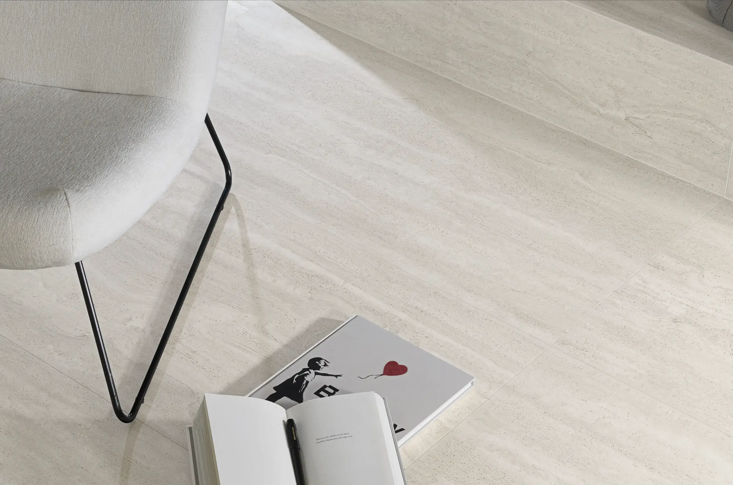 Aeterna porcelain tile corner detail with open book and playing cards on surface – close-up texture shot