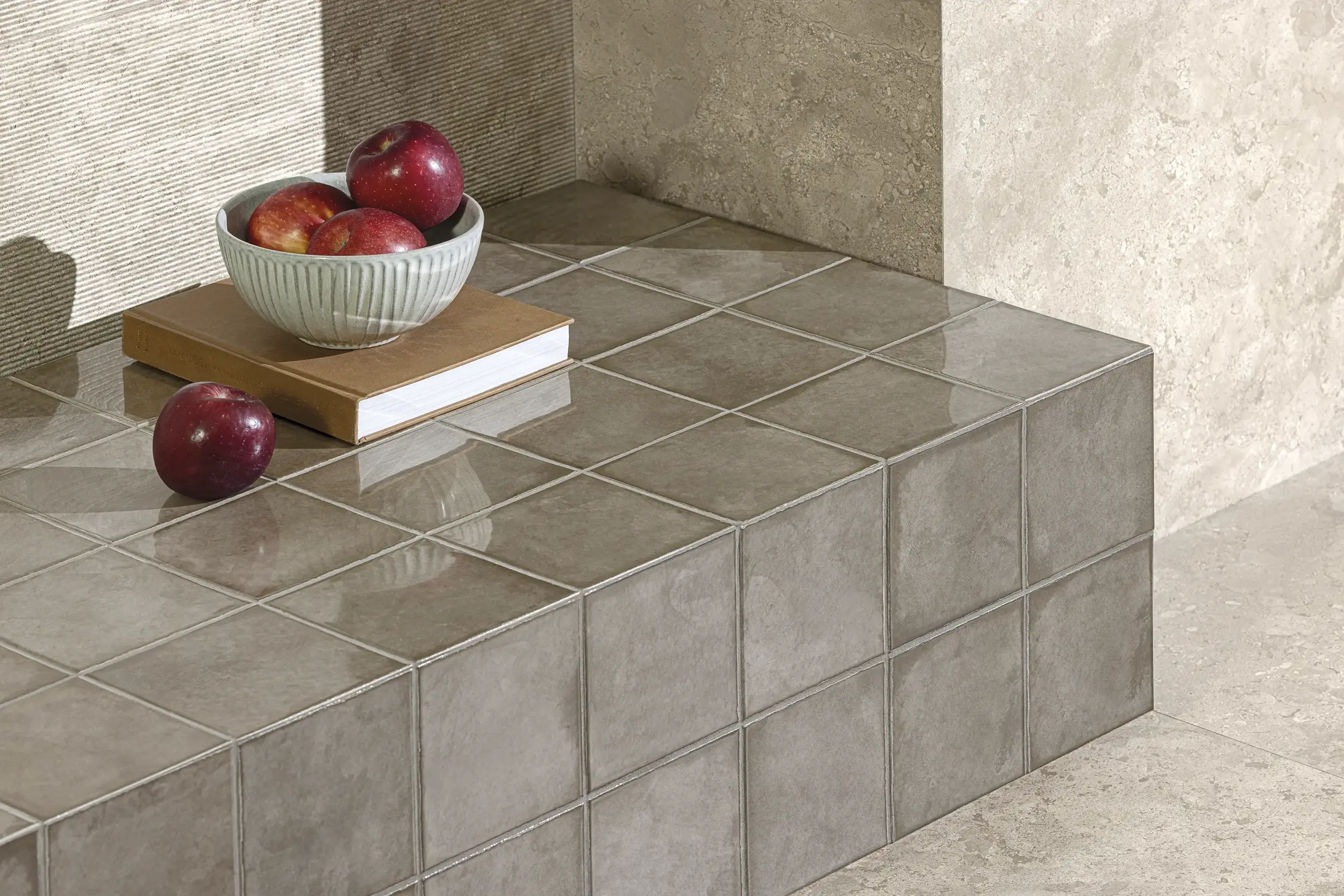 Glossy square tiles in warm beige with fruit and books