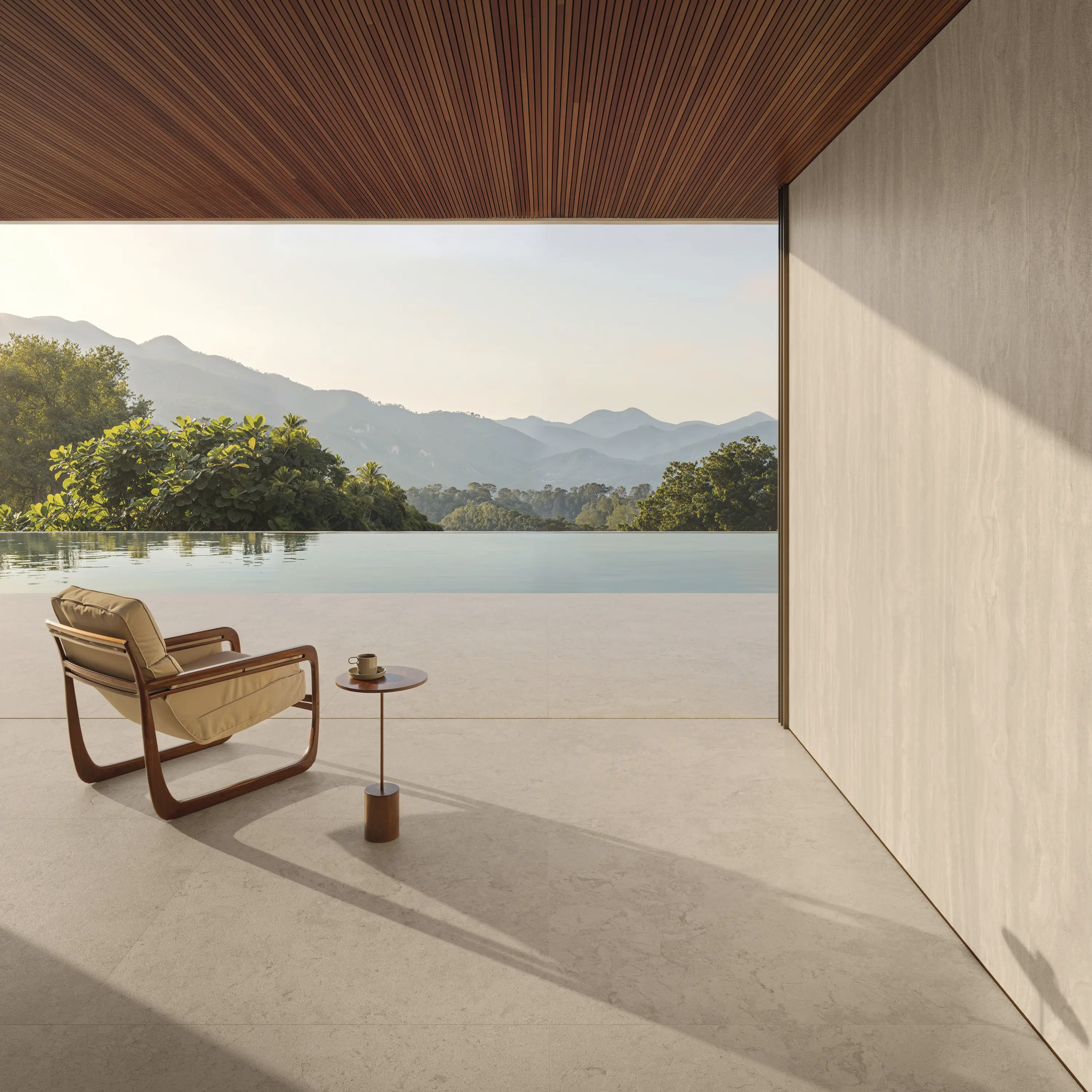 Minimalist indoor-outdoor space with beige flooring and lounge chair facing a pool view
