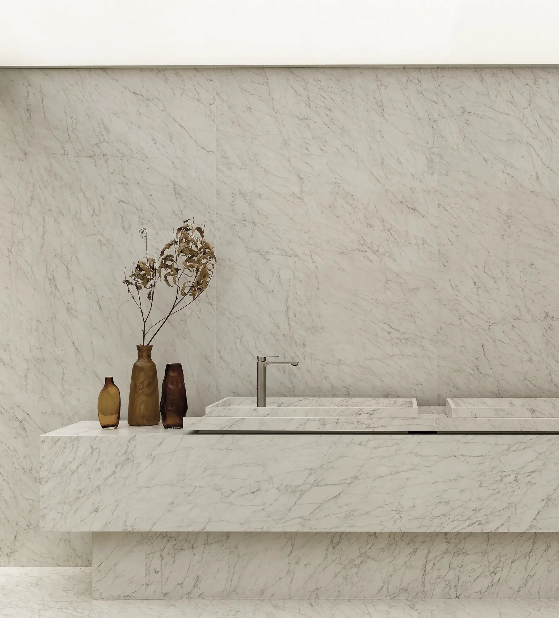 Beige stone-look wall and countertop with integrated sink and minimalist decor objects - Carrara Icon