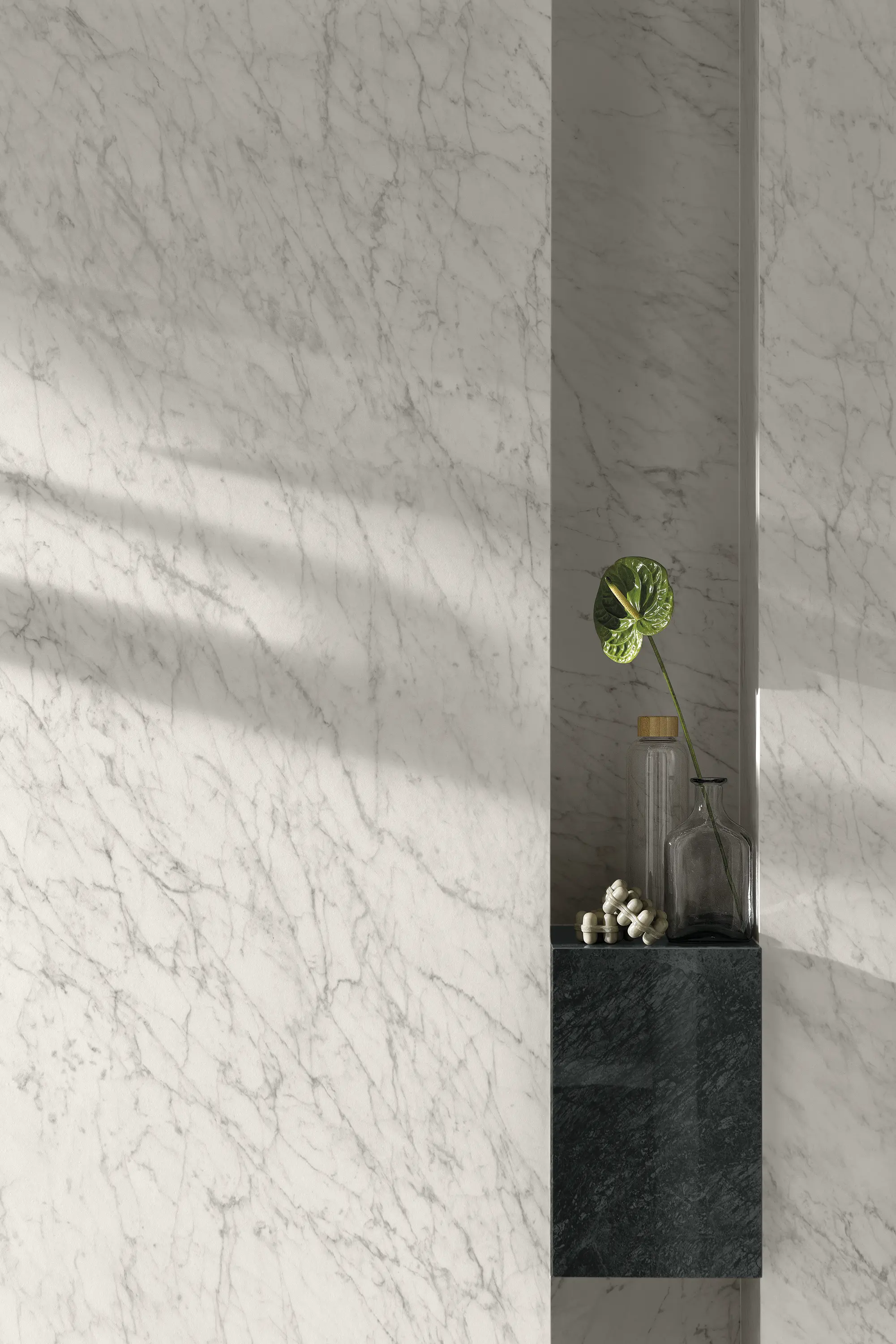Light marble-look wall with soft veining and a narrow shelf with a small plant - Carrara Icon