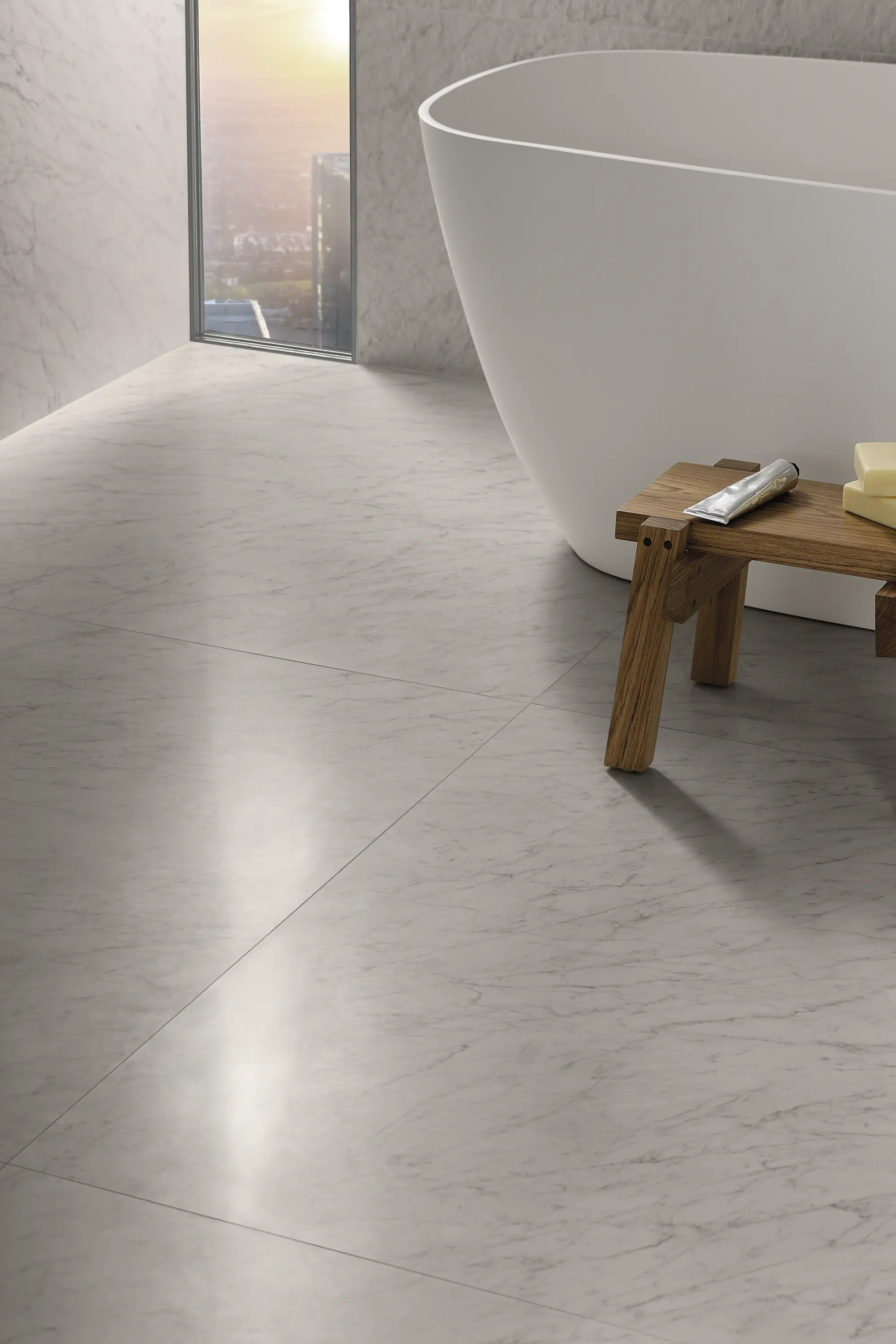 Light beige stone-look floor in a hallway with a wooden bench and soft natural lighting - Carrara Icon