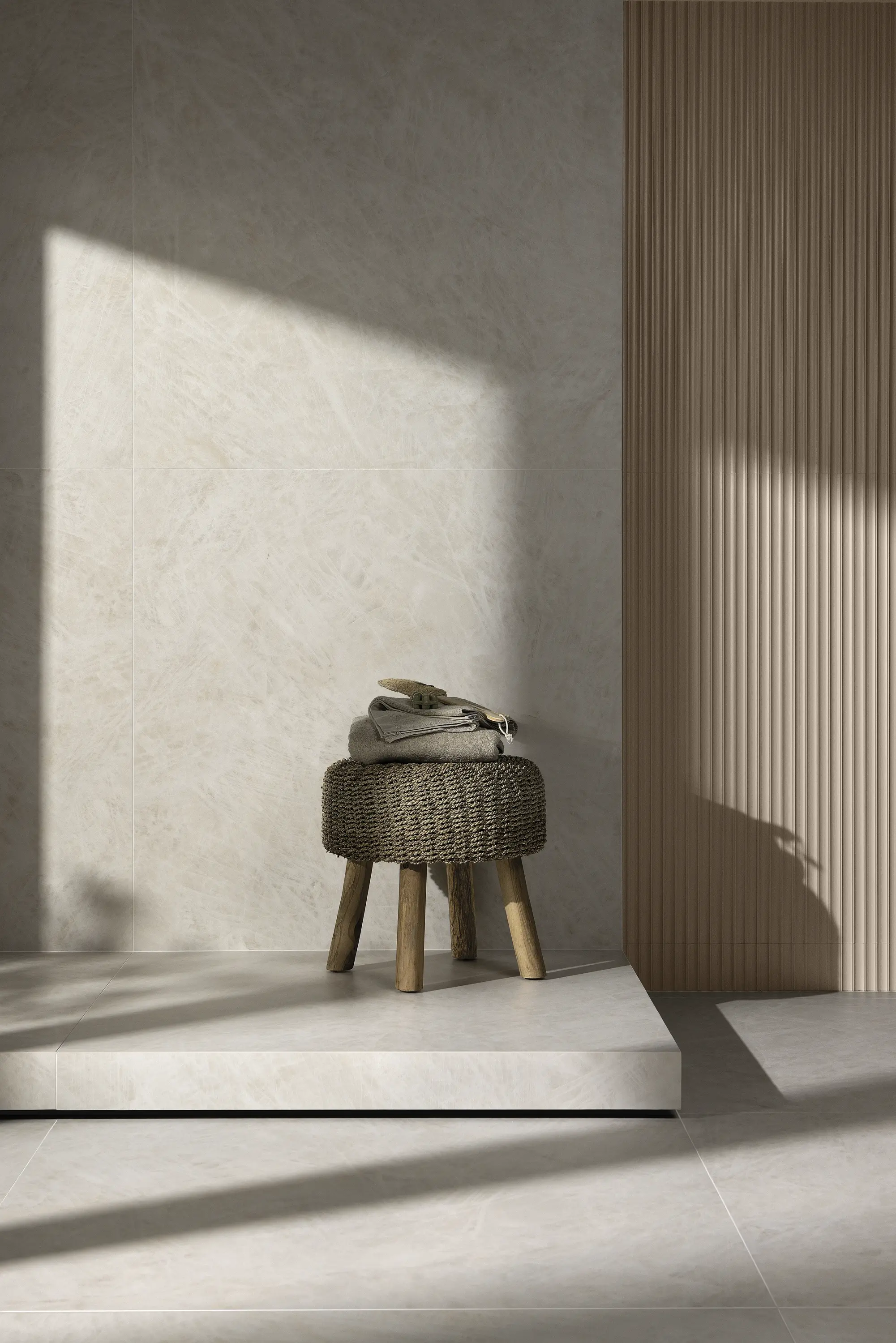 Soft beige wall with natural light and a small stool in a minimal setting - Cristallo Bianco